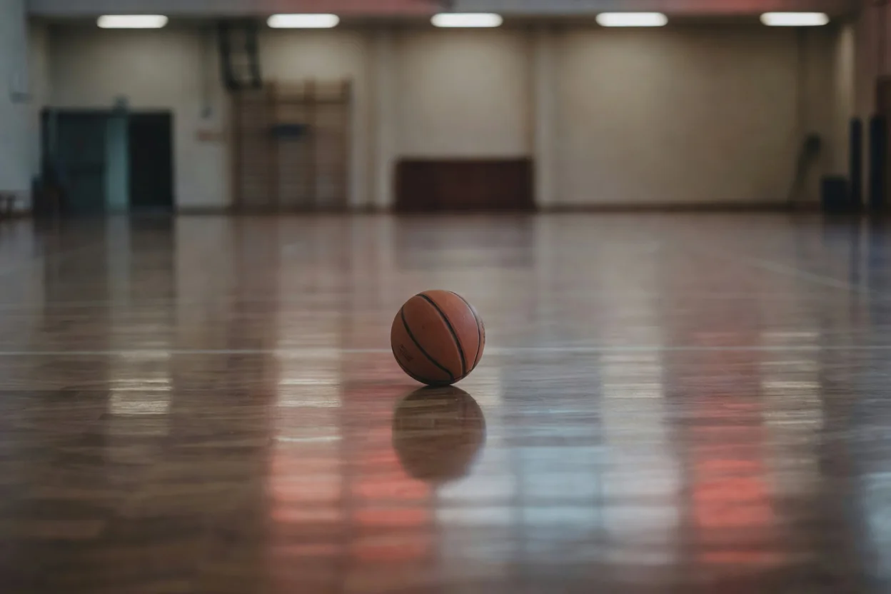 Parke üzerinde basketbol topu ve kırmızı beyaz ışık yansımaları