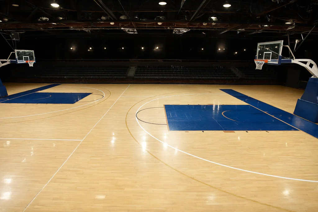 Boş kapalı salon basketbol sahasının üstten görünümü, üç sayı yayı ve parke zemin